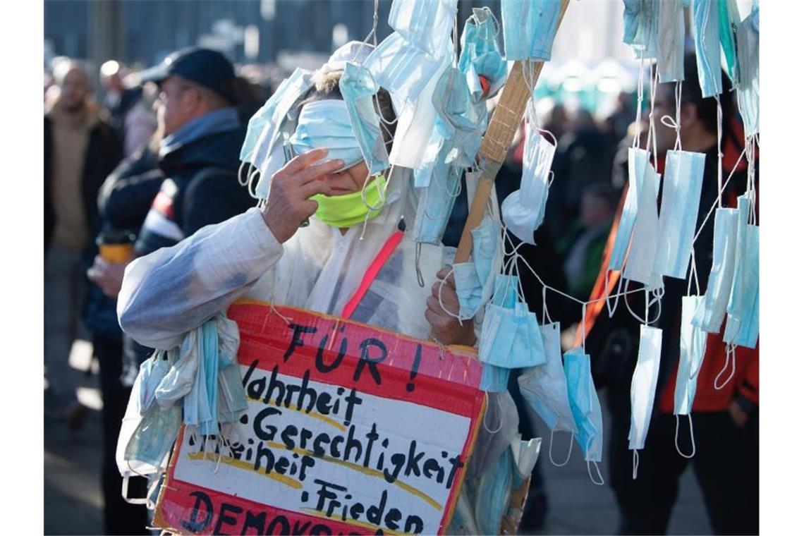 Sachsens Innenminister nach „Querdenken“-Demo unter Druck Eine Demonstrant steht mit einem selbst gebastelten „Masken-Baum“ auf dem Augustusplatz in Leipzig. Foto: Sebastian Kahnert/dpa-Zentralbild/dpa