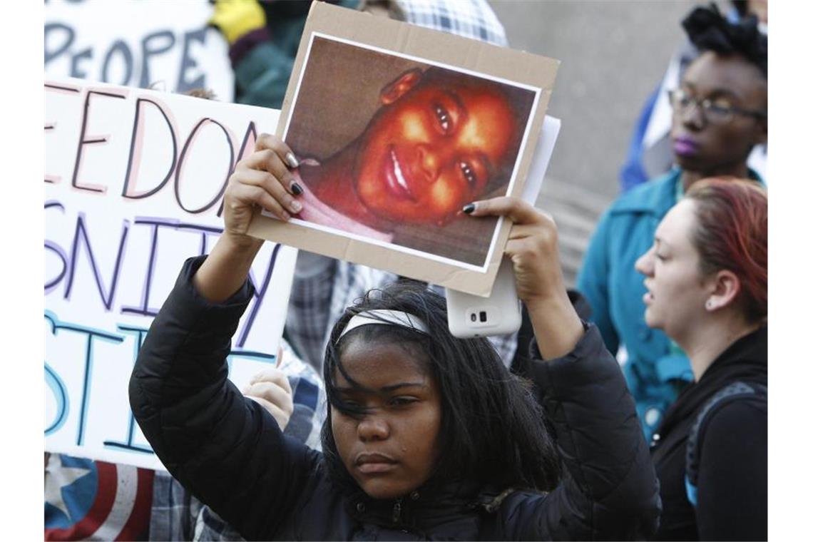 Eine Demonstrantin bei einer Kundgebung auf dem Public Square in Cleveland mit einem Konterfei von Tamir Rice. Foto: David Maxwell/EPA/dpa