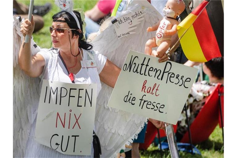 Eine Demonstrantin mit Schildern nimmt an einer Demonstration der Initiative „Querdenken“ teil. Foto: Christoph Schmidt/dpa/Archivbild
