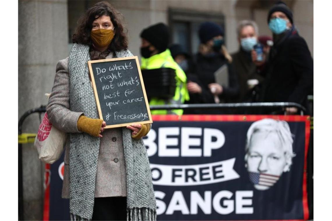 Eine Demonstrantin steht vor dem Strafgerichtshof Old Bailey mit einer Tafel mit der Aufschrift "Do what's right not what's best for your career - #Freeassange" (Tun Sie, was richtig ist, nicht was für Ihre Karriere das Beste ist). Foto: Yui Mok/PA Wire/dpa