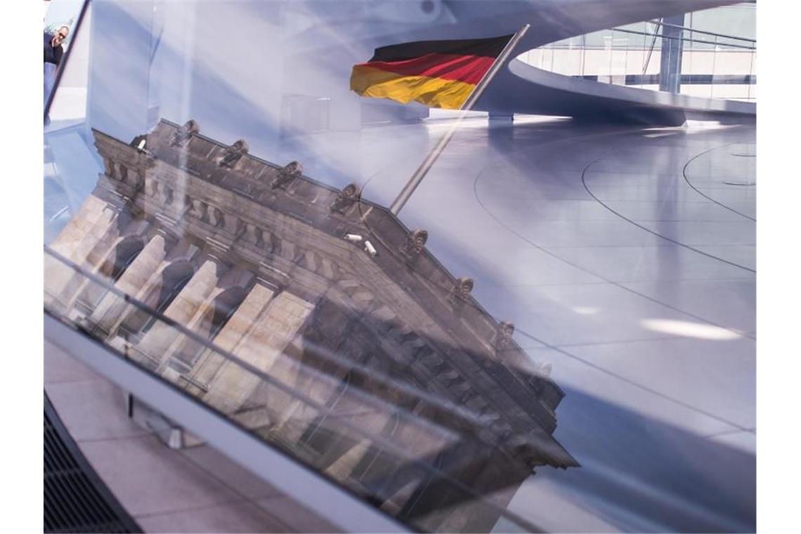 Vertrauen in politische Ämter und Institutionen gewachsen Eine Deutschland-Fahne spiegelt sich in der Kuppel des Reichstagsgebäudes. Foto: Sophia Kembowski/dpa