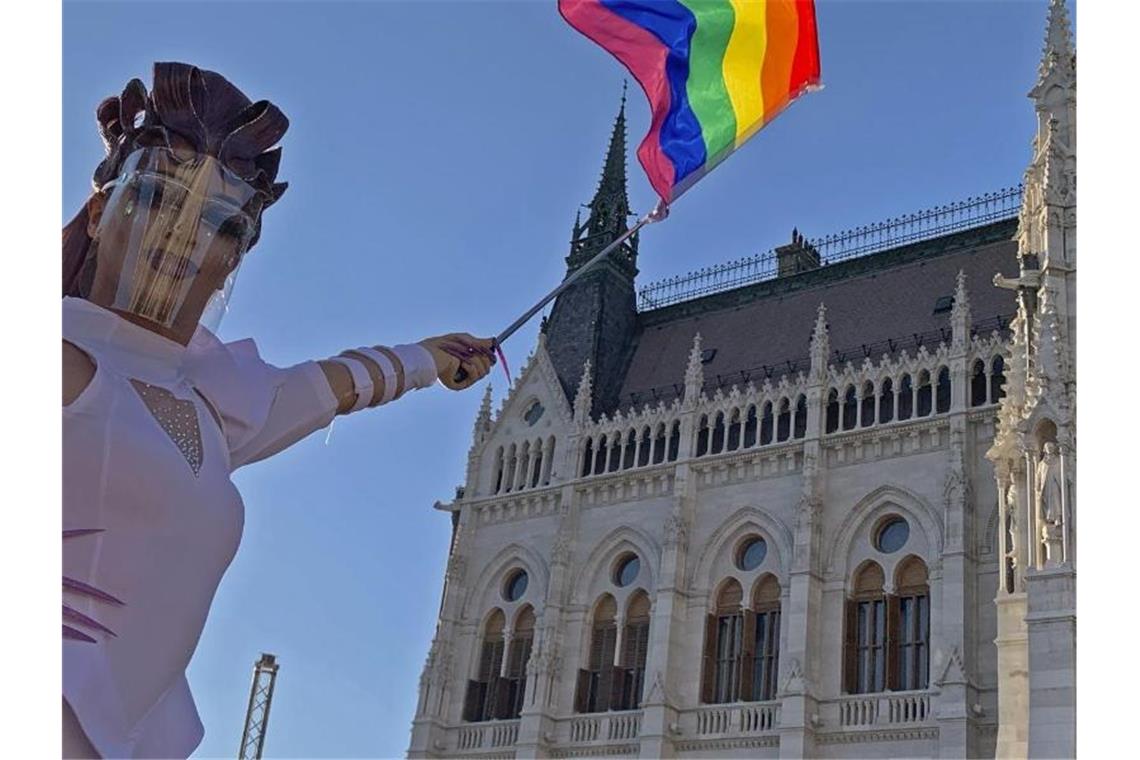 Eine Drag Queen schwenkt eine Regenbogenfahne auf einer LGBT-Rechte-Demonstration vor dem ungarischen Parlament. Foto: Bela Szandelszky/AP/dpa