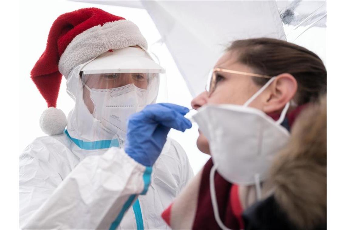 DRK: Infektionsrate bei Schnelltests unter halbem Prozent Eine DRK-Helferin mit Bommelmütze führt einen Corona-Schnelltest an einer Frau durch. Foto: Marijan Murat/dpa