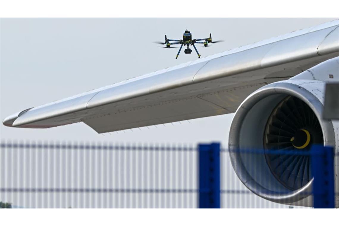 Eine Drohne der Polizei ist am 5. August 2026 über einer Flugzeugtragfläche auf dem Leipziger Flughafen zu sehen. 