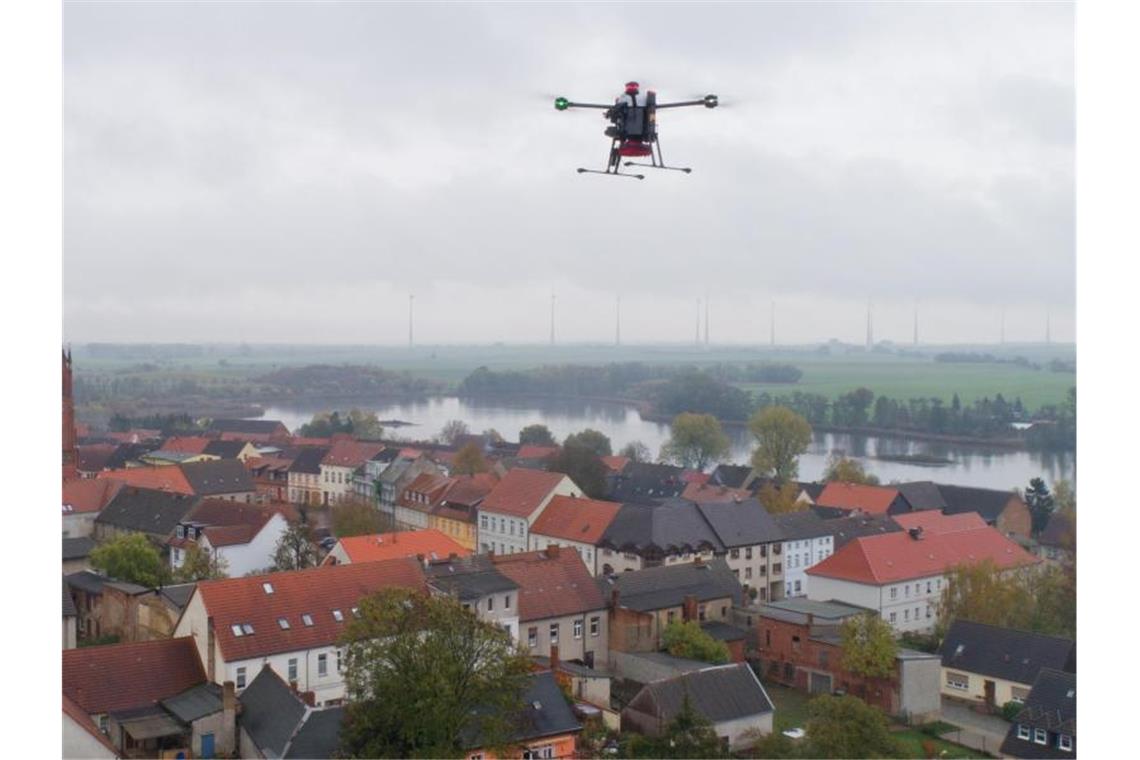 Eine Drohne fliegt über einen Ort. Foto: Stefan Sauer/zb/dpa