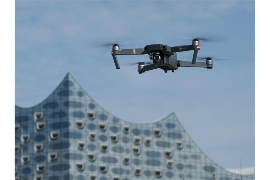 Über Hamburgs Hafen werden Drohnen-Lufträume getestet Eine Drohne schwebt in Hamburg vor der Elbphilharmonie. Foto: picture alliance / Axel Heimken/dpa