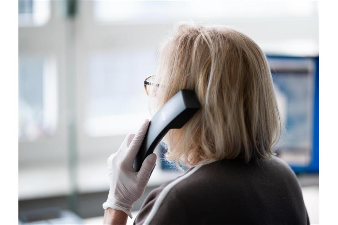 Eine ehrenamtliche Telefonseelsorgerin telefoniert. Foto: Daniel Reinhardt/dpa/Symbolbild