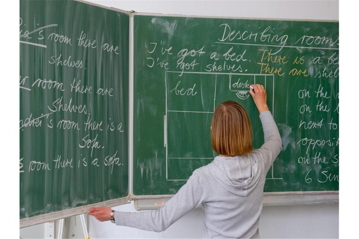 Eine Englisch-Lehrerin einer Grundschule schreibt Unterrichtsinhalte an die Tafel. Foto: Patrick Pleul/dpa-Zentralbild/dpa/Symbolbild