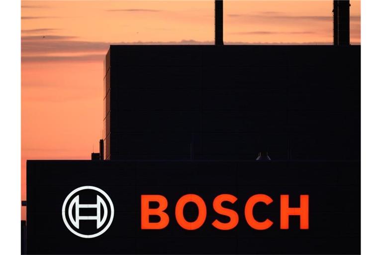 Eine Fabrik von Bosch zeichnet sich bei Sonnenuntergang als Silhouette ab. Foto: Sebastian Kahnert/dpa-Zentralbild/dpa/Archivbild