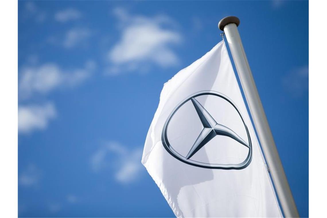 Eine Fahne mit dem Logo von Mercedes-Benz weht im Wind. Foto: Tom Weller/dpa/Archivbild