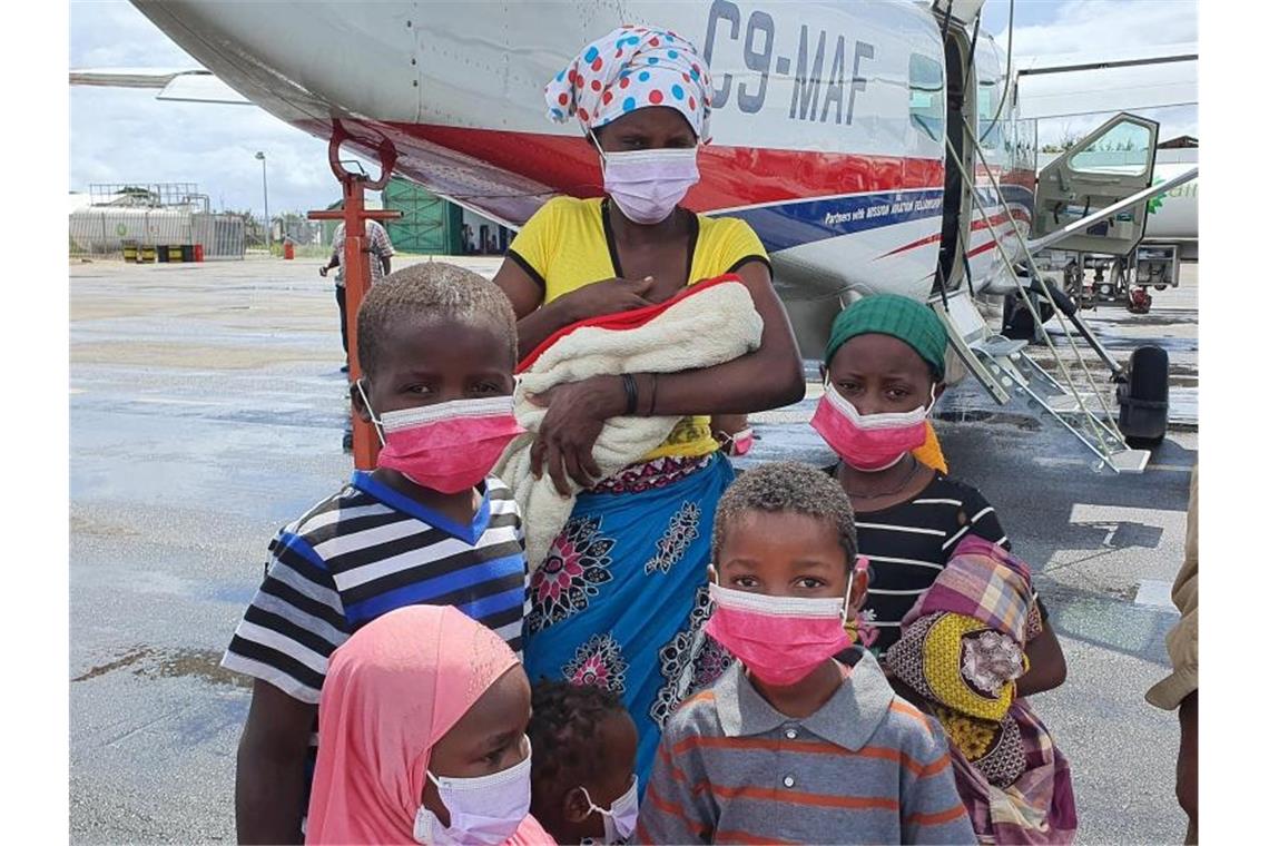 Eine Familie auf dem Rollfeld des Flughafens der Provinzhauptstadt Pemba. In Mosambik sind nach Angaben des Welternährungsprogramms (WFP) annähernd eine Million Menschen infolge von Terror und Gewalt vom Hunger bedroht. Foto: Dave Lepoidevin/Ambassador Aviation/AP/dpa
