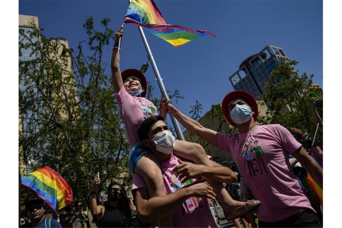 Eine Familie nimmt fahnenschwenkend an der jährlichen Gay Pride Parade in Chiles Hauptstadt teil. Foto: Esteban Felix/AP/dpa