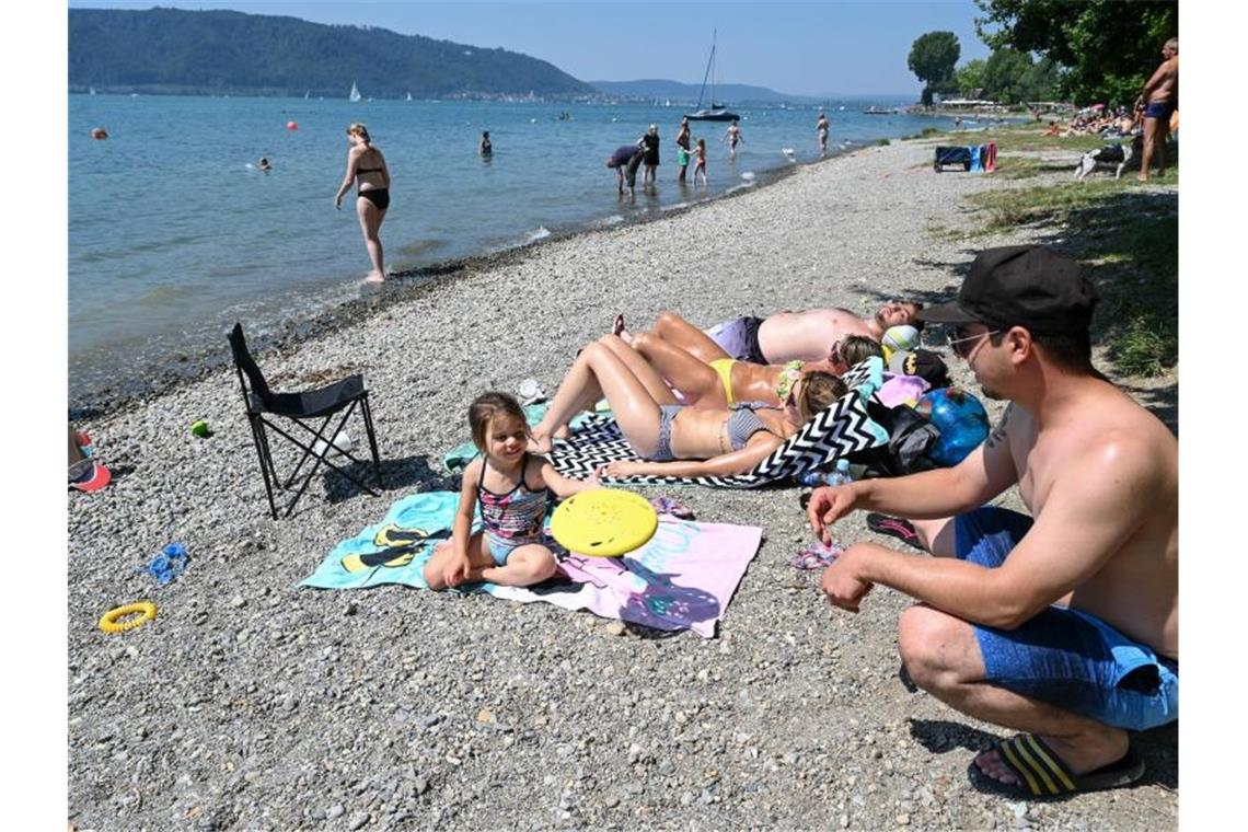 Eine Familie verbringt den Hitzetag am Ufer des Bodensees. Foto: Felix Kästle/dpa