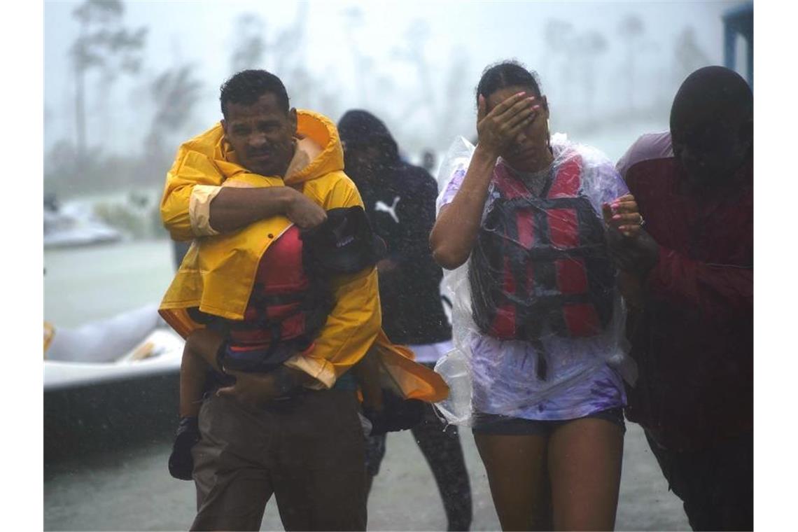 Eine Familie wird in Freeport auf den Bahamas in eine sichere Zone begleitet. Foto: Ramon Espinosa/AP