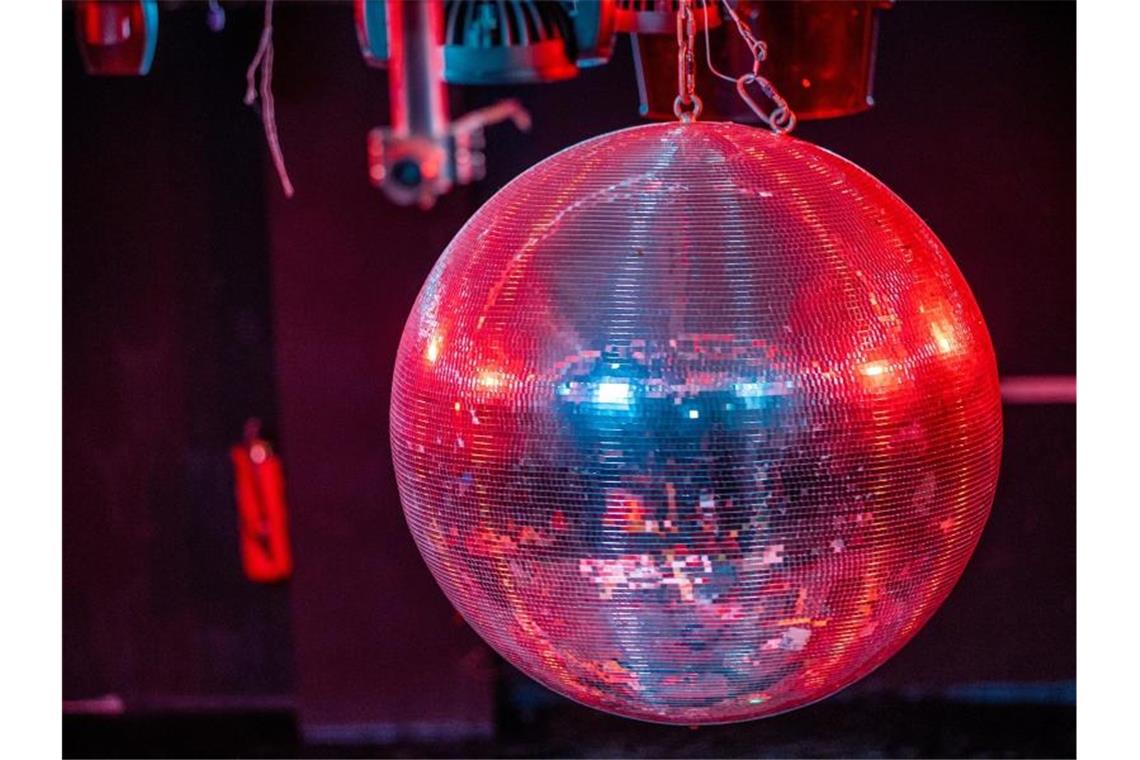 Feiern ohne Maske in Südwest-Clubs unter Bedingungen erlaubt Eine farbig beleuchtete Discokugel dreht sich über der Tanzfläche in einer Diskothek. Foto: Jens Büttner/dpa-Zentralbild/ZB/Symbolbild