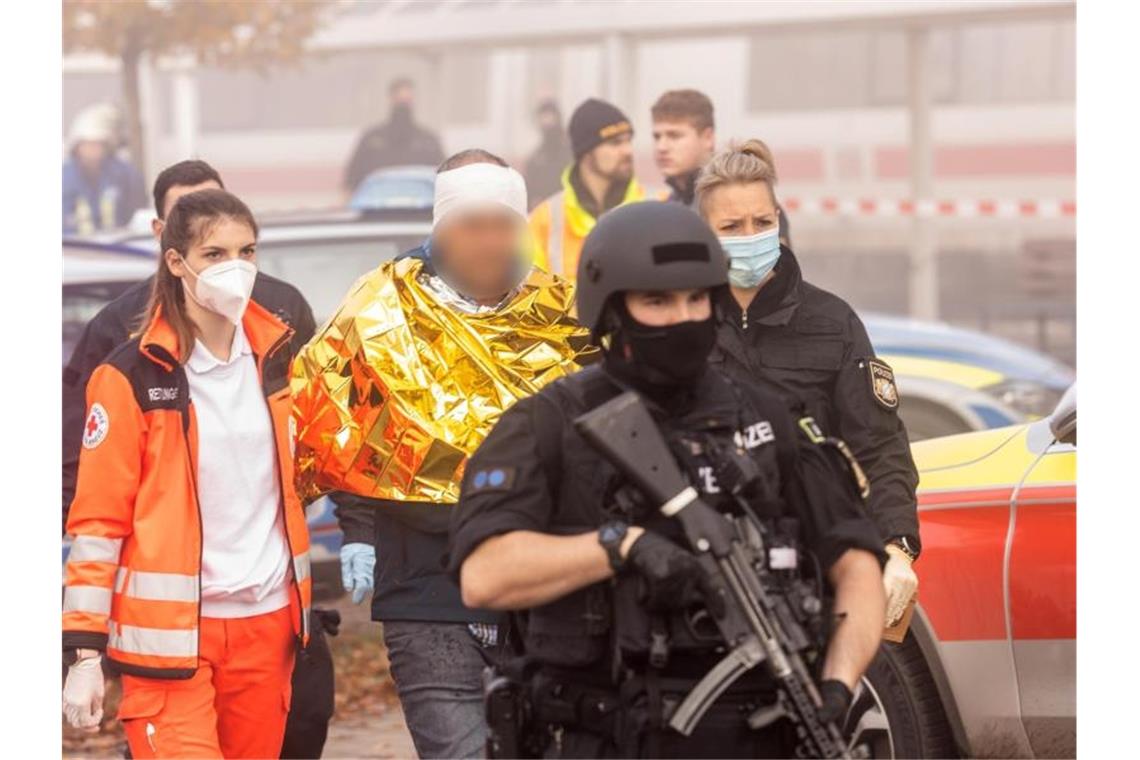 Eine festgenommene männliche Person wird von Polizei und Rettungskräften weggeführt. Foto: Fabian Schreiner/dpa