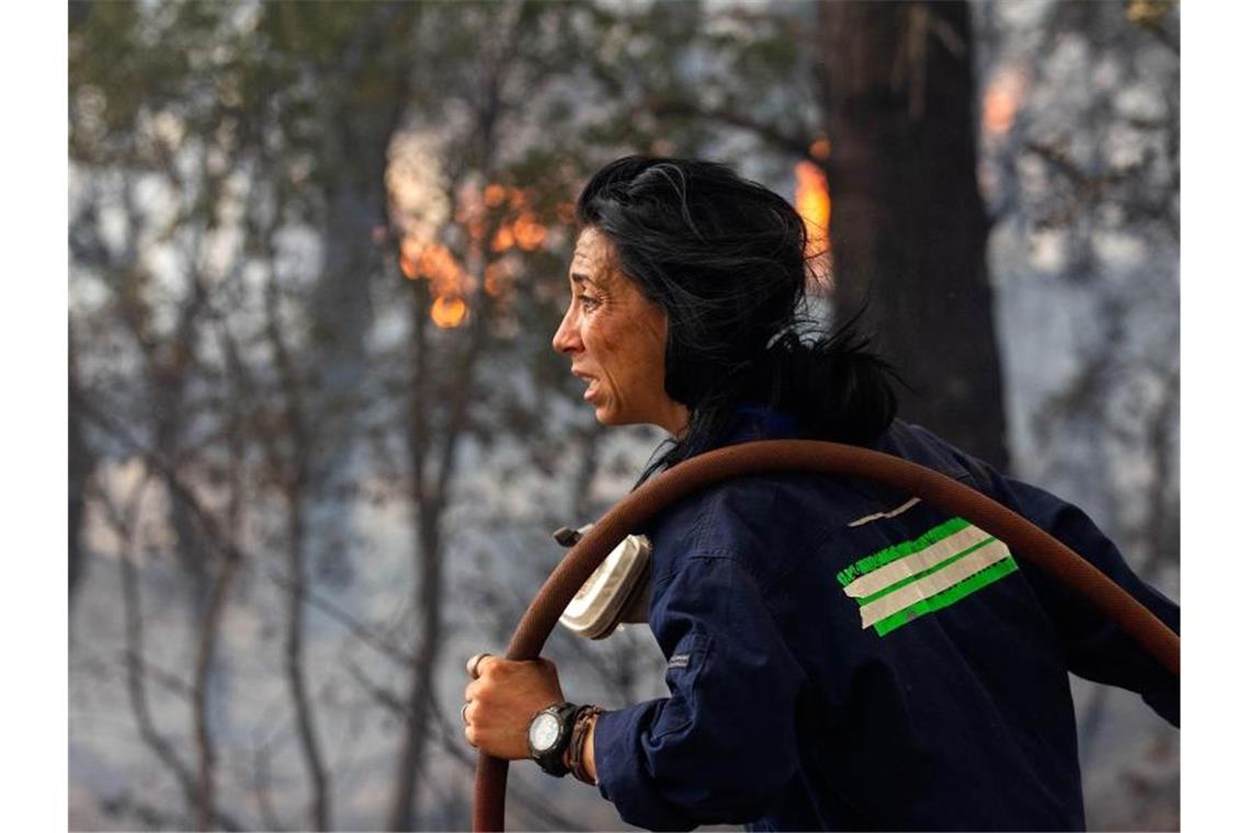 „Wir haben kein Wasser!“ - dramatische Szenen auf Euböa Eine Feuerwehrfrau versucht ein Feuer etwa 30 Kilometer von der griechischen Hauptstadt Athen zu löschen. Vielerorts sind die Brände außer Kontrolle geraten, es kommt zunehmend internationale Hilfe an. Foto: Marios Lolos/XinHua/dpa
