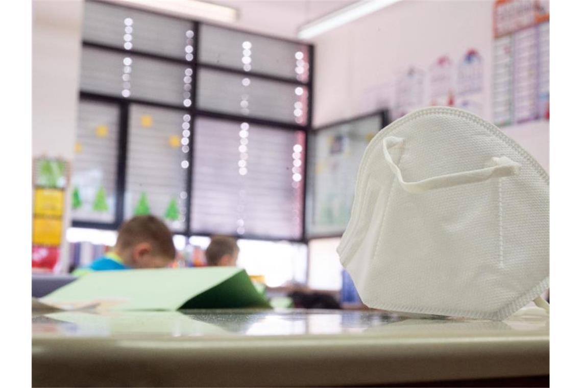 Weitere Bundesländer lockern Maskenpflicht an Schulen Eine FFP2-Maske liegt in einer Grundschule auf einem Tisch. In zwei Bundesländern greifen ab Montag Lockerungen bei der Maskenpflicht an Schulen. Foto: Sebastian Gollnow/dpa