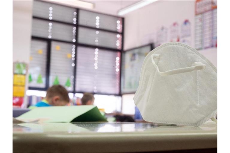 Eine FFP2-Maske liegt in einer Grundschule auf einem Tisch. In zwei Bundesländern greifen ab Montag Lockerungen bei der Maskenpflicht an Schulen. Foto: Sebastian Gollnow/dpa