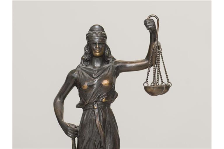 Eine Figur „Justitia“ steht auf einem Schreibtisch. Foto: picture alliance / dpa
