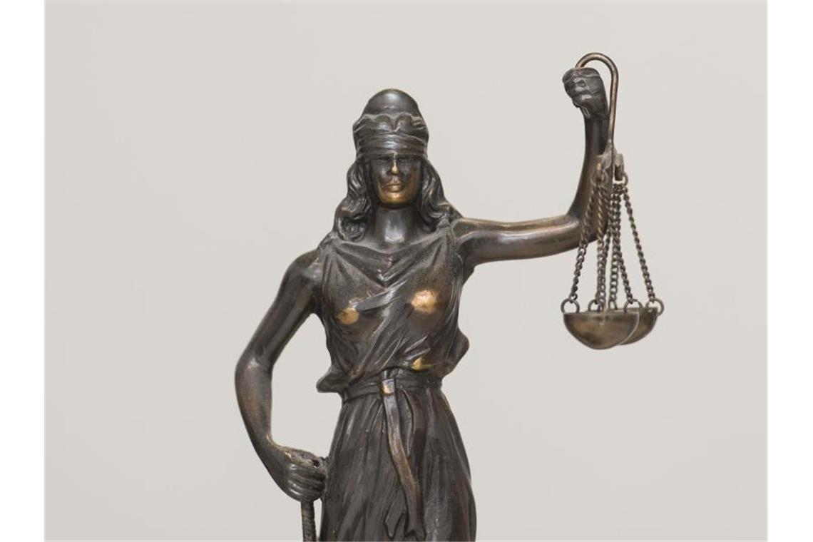 Eine Figur „Justitia“ steht auf einem Tisch. Foto: picture alliance / dpa/Archivbild