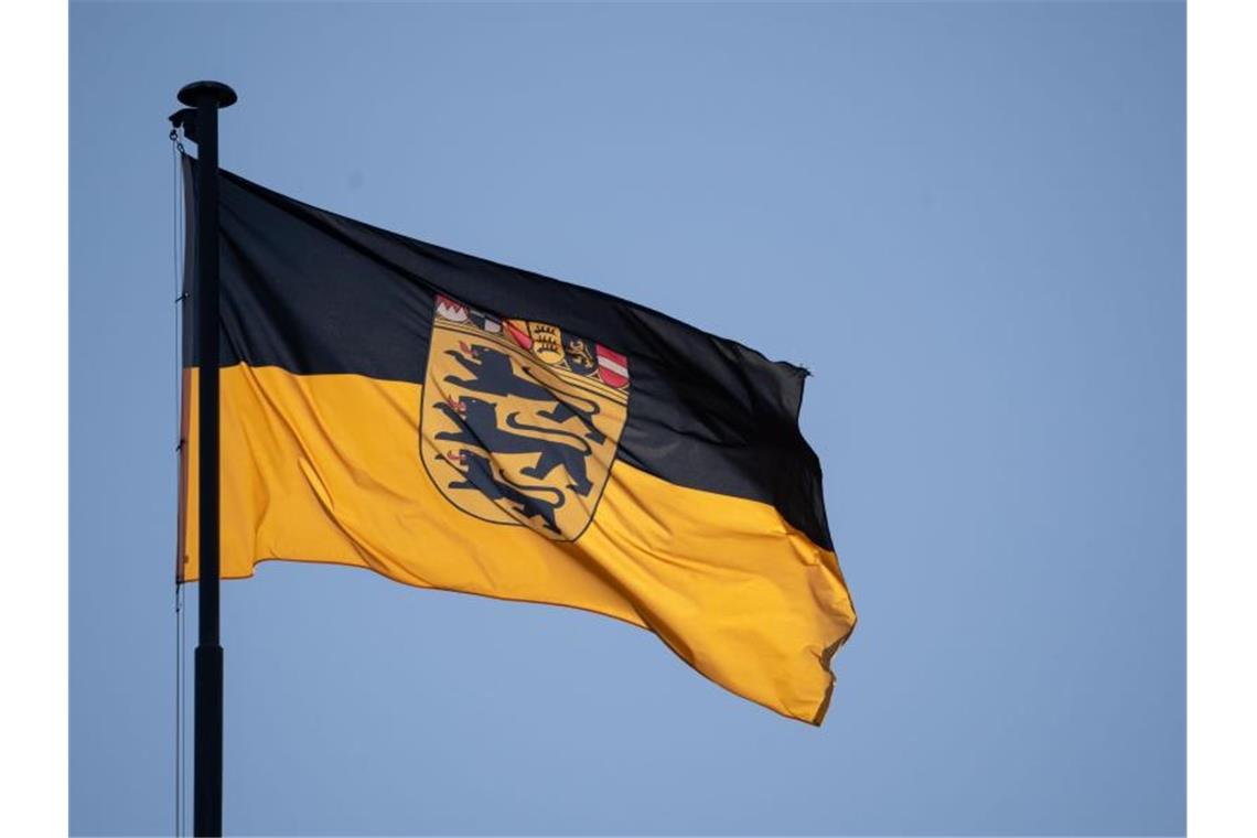 Eine Flagge des Landes Baden-Württemberg weht vor blauem Himmel im Wind. Foto: Marijan Murat/dpa/Archivbild