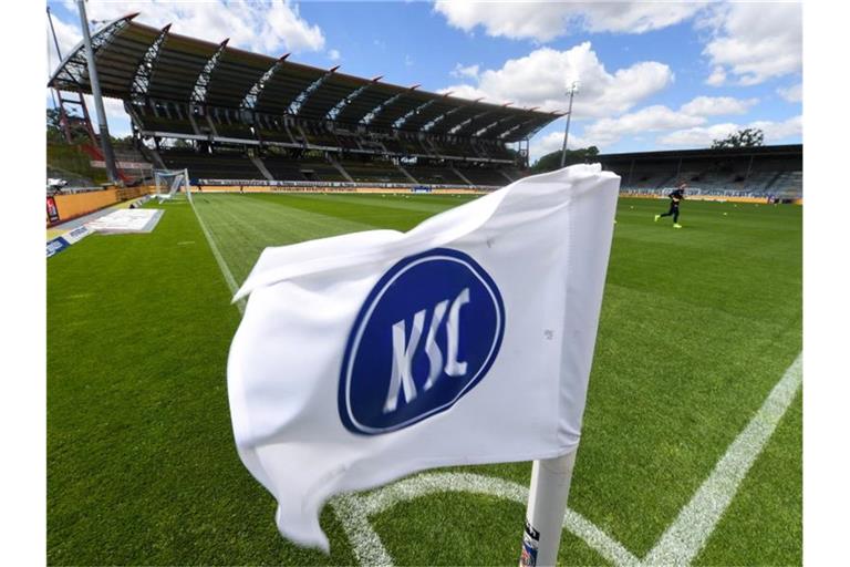Eine Flagge mit dem Logo von Karlsruher SC ist im Stadion mit leeren Tribünen zu sehen. Foto: Uli Deck/dpa-Pool/dpa/Archivbild