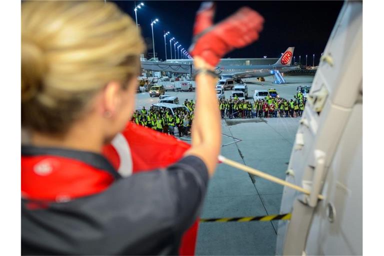 Eine Flugbegleiterin der Fluggesellschaft Air Berlin winkt am auf dem Flughafen in München weiteren Mitarbeitern der Airline vor dem letzten Flug zur Verabschiedung. Foto: Gregor Fischer/dpa