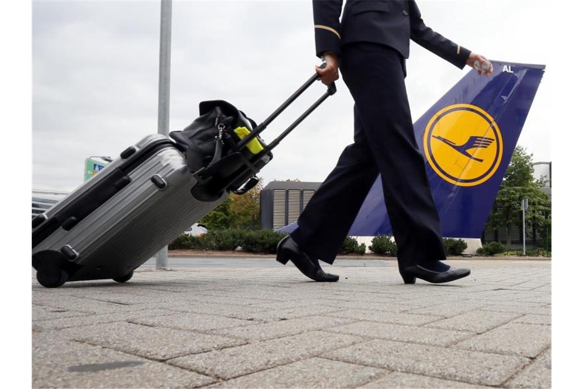 Eine Flugbegleiterin geht auf dem Flughafen in Frankfurt am Main in die Lufthansa-Basis. Foto: Frank Rumpenhorst/dpa