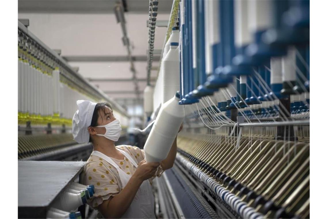 Eine Frau arbeitet in einer Textilfabrik in der ostchinesischen Provinz Jiangsu. Die G20 wollen Job-Bedingungen für Frauen verbessern. Foto: CHINATOPIX/AP/dpa