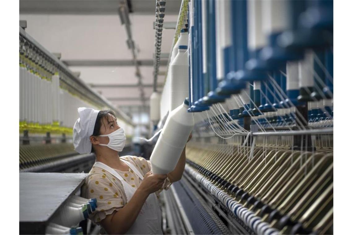 Eine Frau arbeitet in einer Textilfabrik in der ostchinesischen Provinz Jiangsu. Foto: CHINATOPIX/AP/dpa