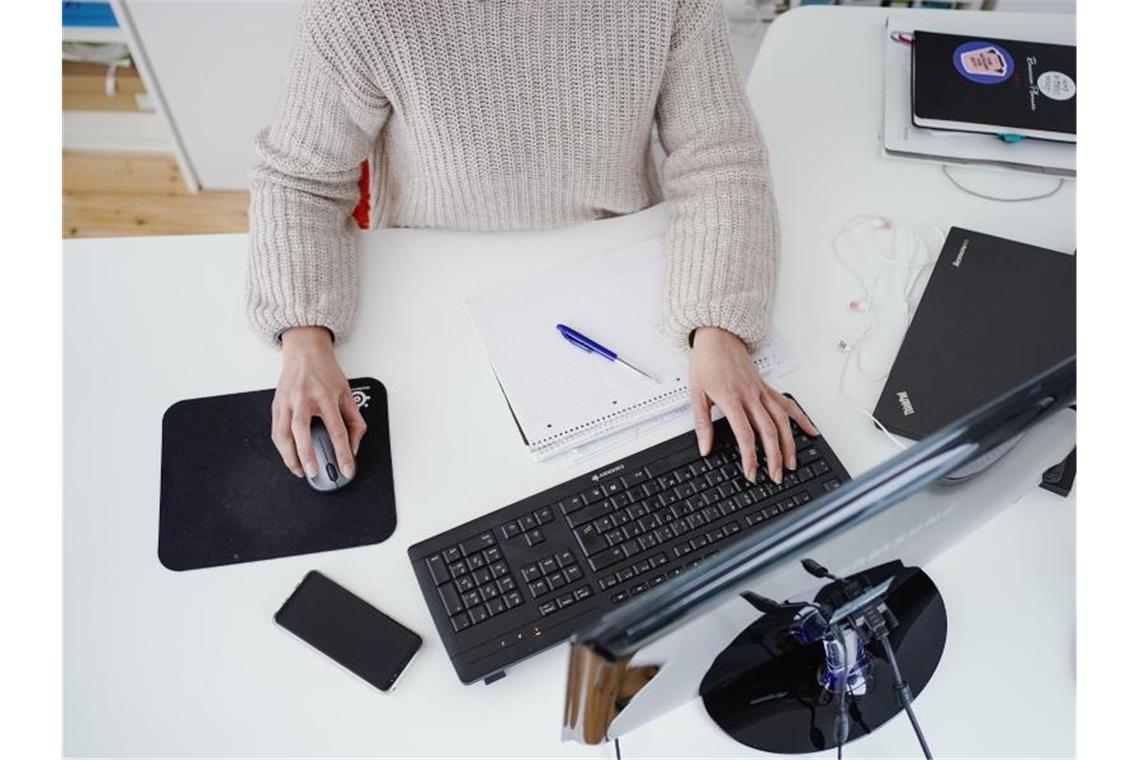 Jüngere Arbeitnehmer drängen laut Umfrage ins Homeoffice Eine Frau arbeitet in ihrer Wohnung vor einem Computer an einem Stehtisch. (Symbolbild). Foto: Uwe Anspach/dpa