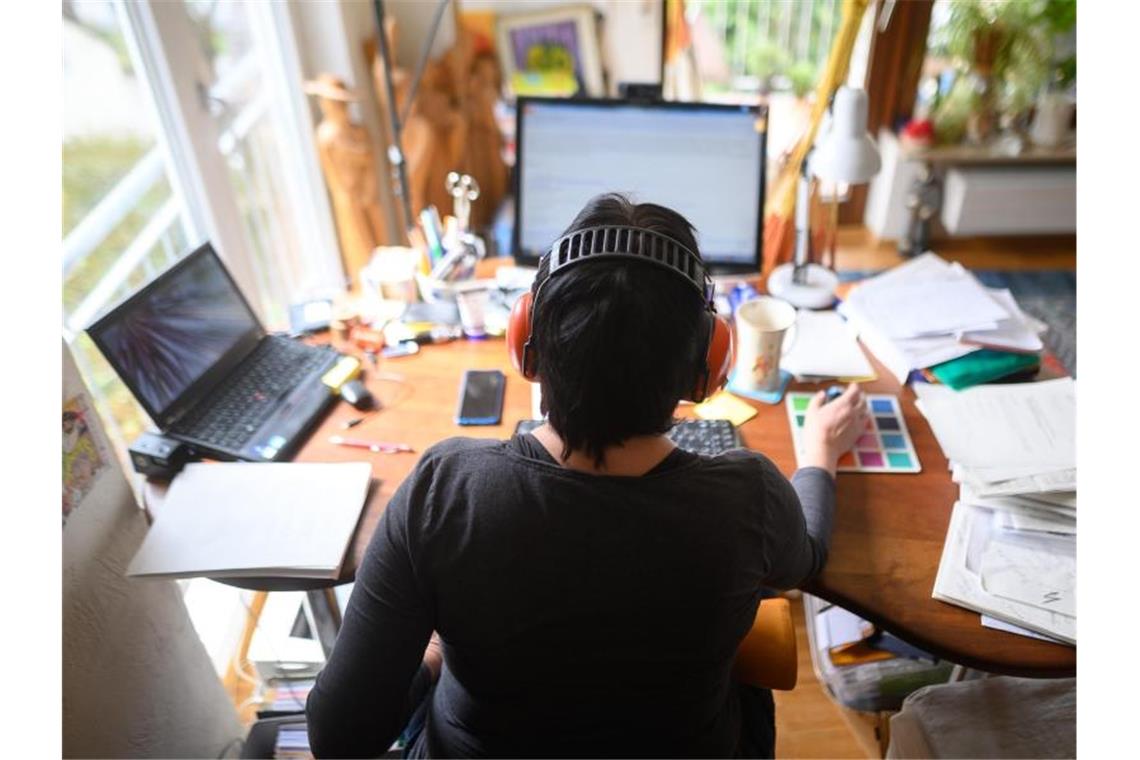 Eine Frau arbeitet mit Hörschutz im Homeoffice. Foto: Sebastian Gollnow/dpa