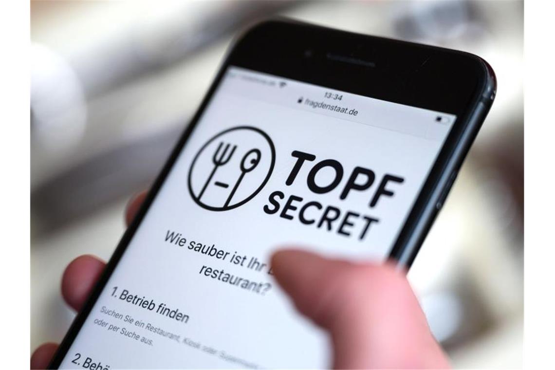 Eine Frau bedient ein Smartphone, auf dem die Webpräsenz der Plattform „Topf Secret“ geöffnet ist. Foto: Marijan Murat/dpa/Archivbild