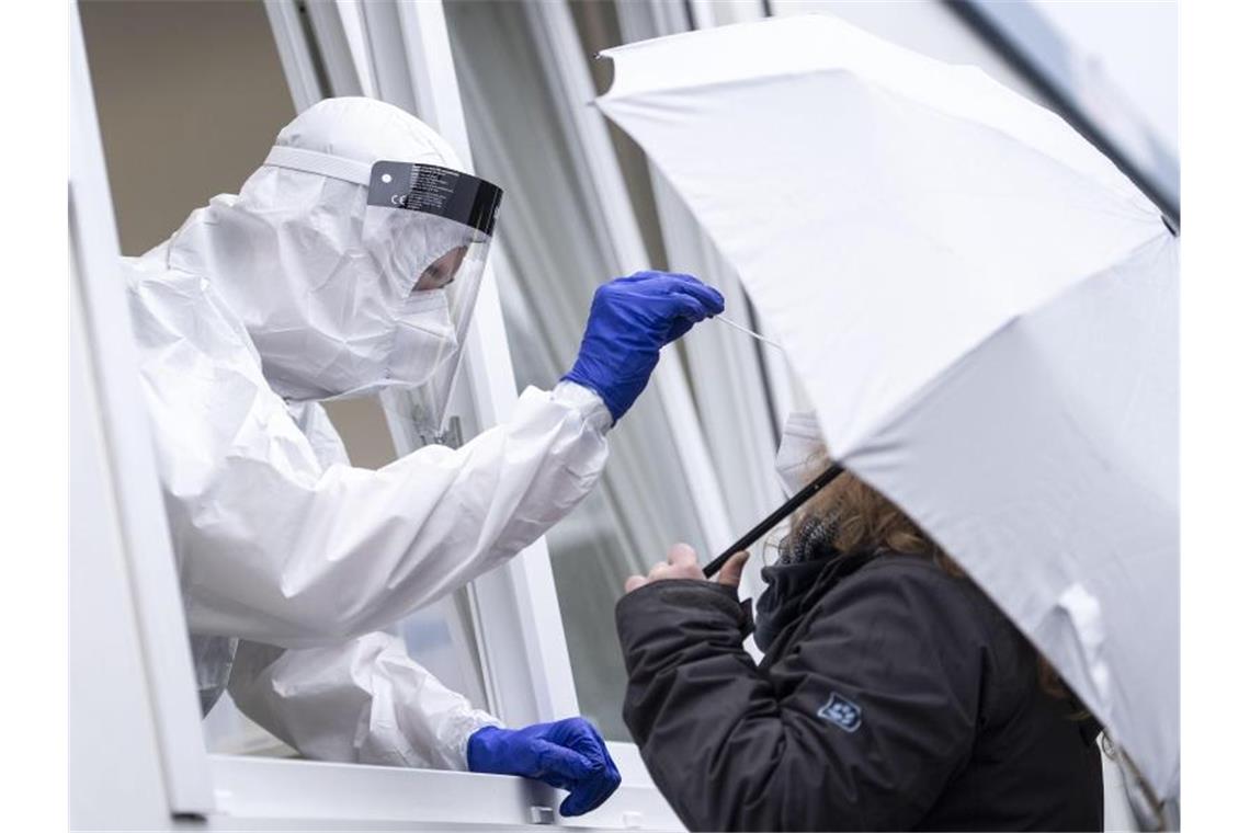 Eine Frau bekommt an der Corona-Teststation am Hauptbahnhof von Köln einen Rachenabstrich. Foto: Marius Becker/dpa