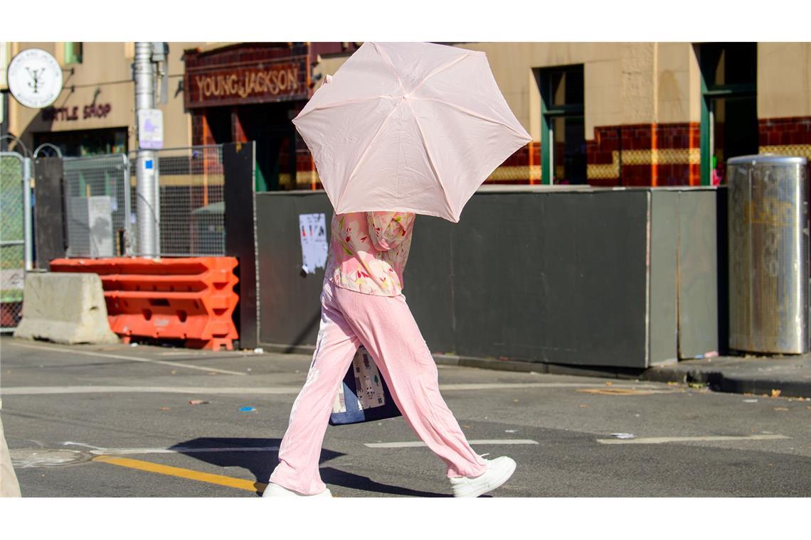 Eine Frau benutzt einen Regenschirm, um sich vor der Sonne zu schützen.