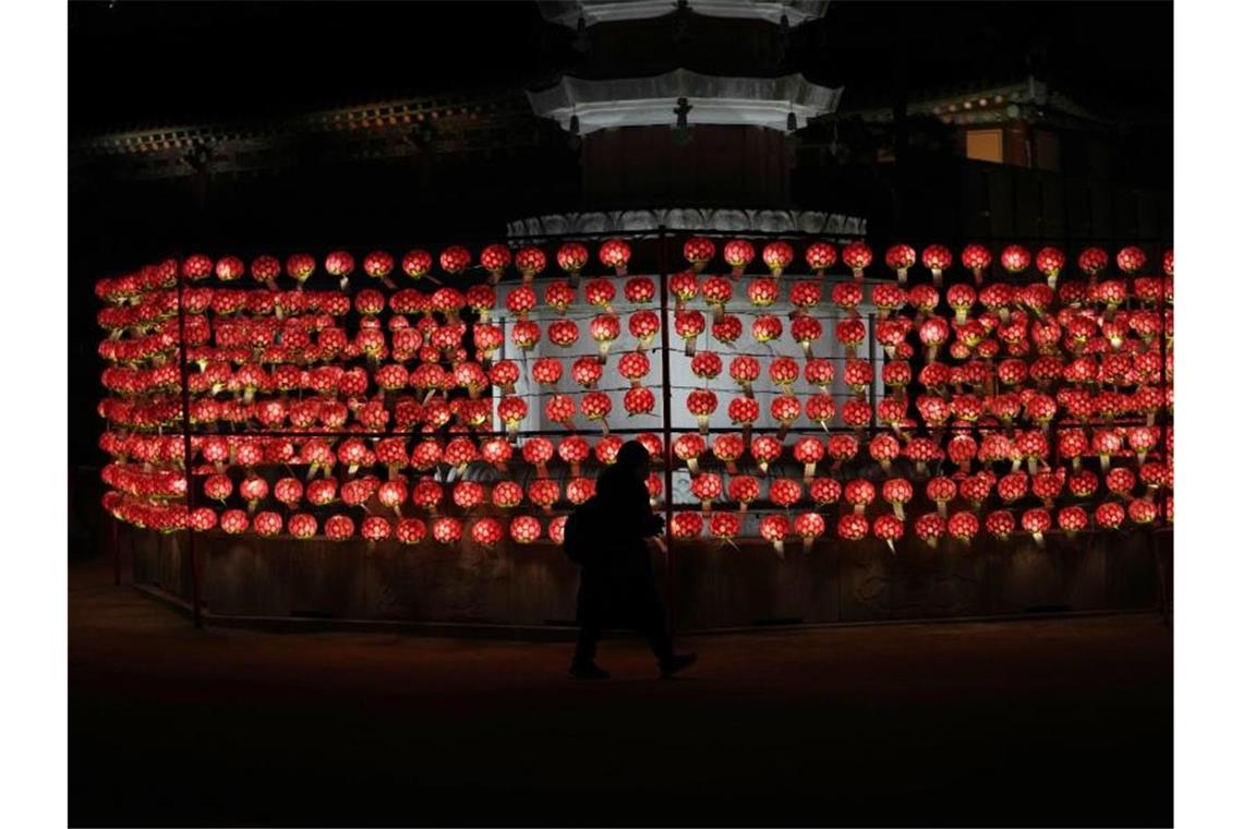 Eine Frau betet am Silvesterabend vor Laternen im Jogye-Tempel in Seoul. Foto: Lee Jin-Man/AP/dpa