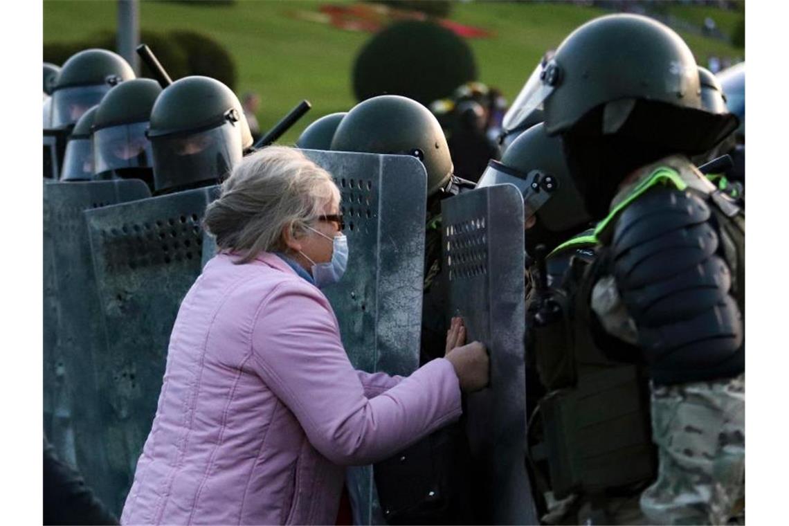 Eine Frau drückt gegen ein Schild eines Polizisten während einer Kundgebung in Minsk. Nach der geheim gehaltenen Amtseinführung Lukaschenkos sind zahlreiche Menschen auf die Straße gegangen. Foto: Uncredited/AP/dpa