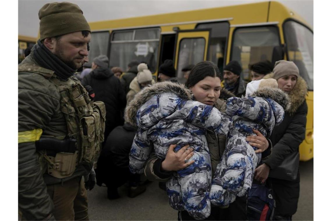 Krieg gegen die Ukraine: So ist die Lage Eine Frau flieht mit zwei Babys aus der ukrainischen Hauptstadt Kiew. Foto: Vadim Ghirda/AP/dpa
