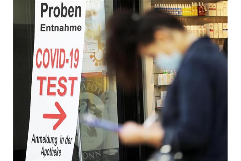 Eine Frau füllt vor einer Apotheke ein Formular für einen Covid-19-Test aus. Das RKI meldet 745 Neuinfektionen sowie eine Sieben-Tage-Inzidenz von 6,0. Foto: Oliver Berg/dpa