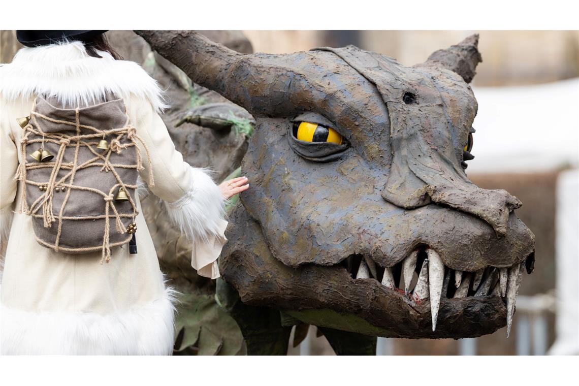 Eine Frau geht beim Mittelalterfest auf der Niederburg in Kranichfeld am Drachen Fangdorn vorbei. Am Karsamstag finden im Freistaat zahlreiche Veranstaltungen und Gottesdienste statt.