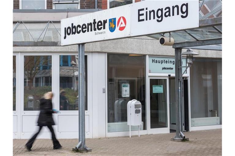 Eine Frau geht in ein Jobcenter der Agentur für Arbeit. Foto: Daniel Bockwoldt/dpa/Archivbild