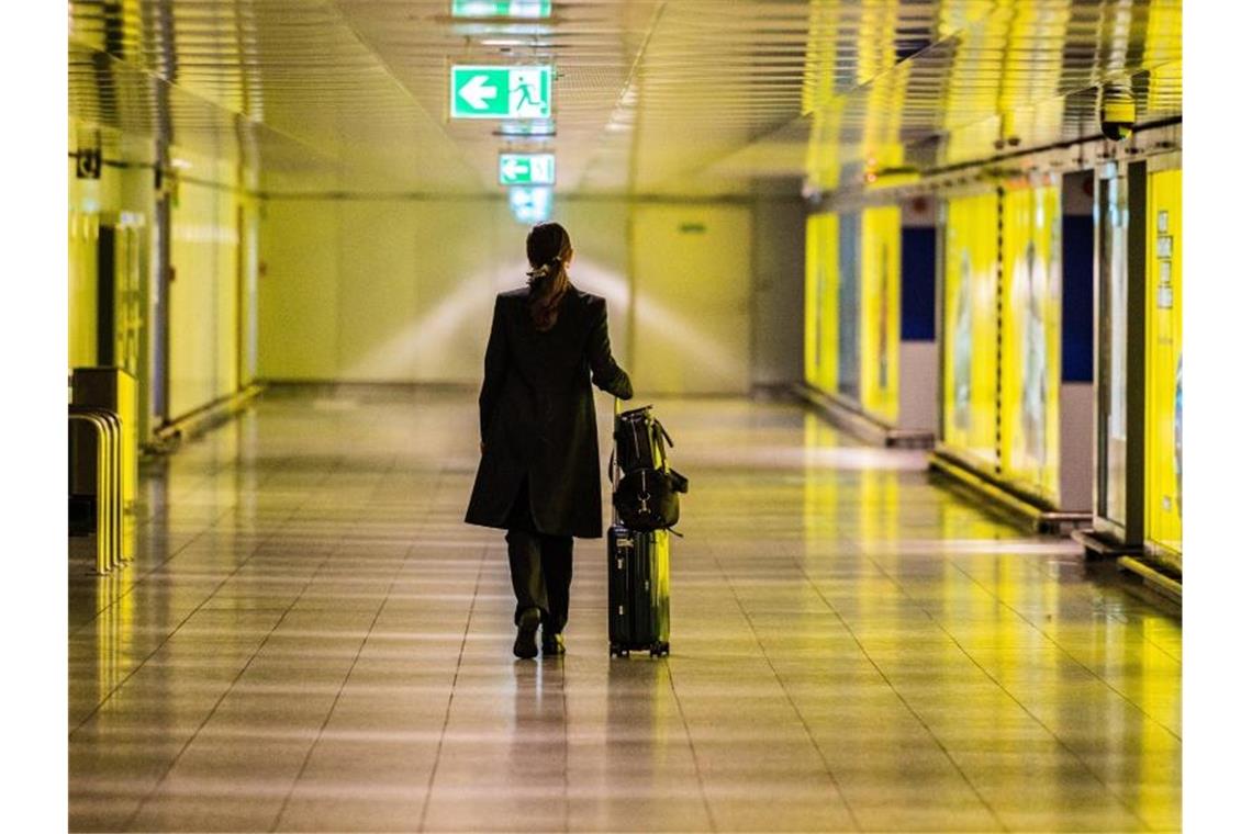 Lufthansa: Besseres ICE-Netz statt Verbot von Inlandsflügen Eine Frau geht mit ihrem Koffer durch einen leeren Gang am Flughafen. Foto: Andreas Arnold/dpa