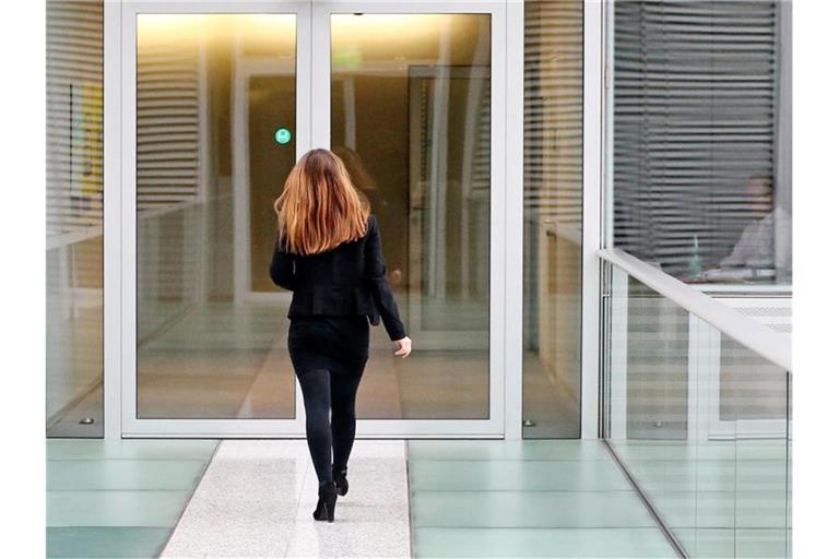 Eine Frau geht über eine Brücke im Gebäude einer Konzernzentrale. Foto: Jan Woitas/ZB/dpa/Symbolbild