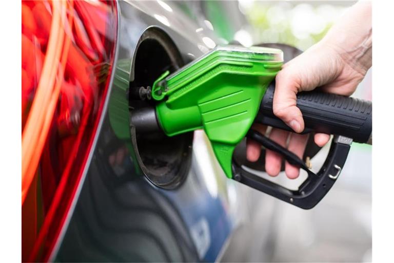 Eine Frau hält an einer Tankstelle an einer Zapfsäule eine Zapfpistole in der Hand und betankt ein Auto. Foto: Sven Hoppe/dpa