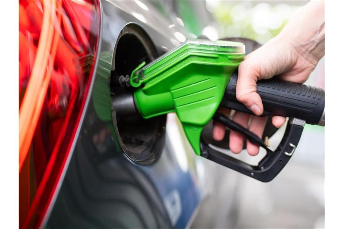 Tanken im Januar fast so teuer wie vor Corona Eine Frau hält an einer Tankstelle an einer Zapfsäule eine Zapfpistole in der Hand und betankt ein Auto. Foto: Sven Hoppe/dpa
