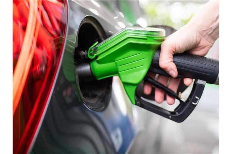 Eine Frau hält an einer Tankstelle an einer Zapfsäule eine Zapfpistole in der Hand und betankt ein Auto. Foto: Sven Hoppe/dpa