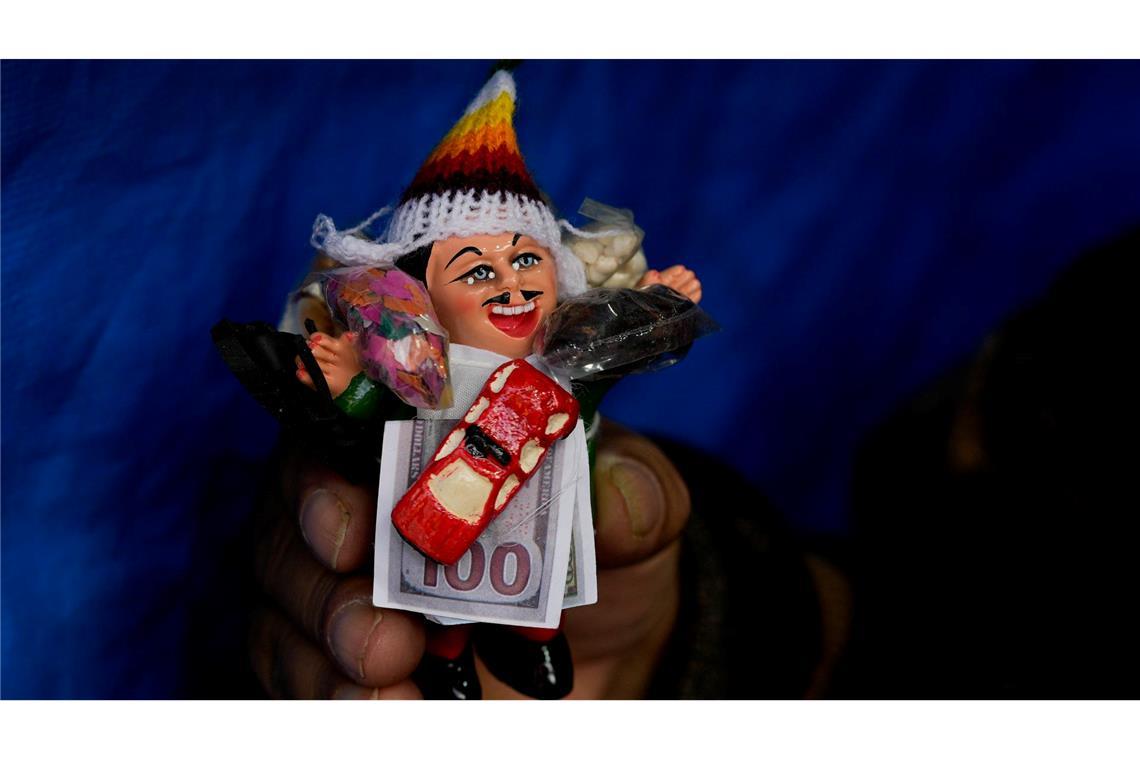 Bilder des Tages Eine Frau hält eine Miniatur von Ekeko, dem andinen Gott des Überflusses und der Fruchtbarkeit, während des jährlichen Alasita-Marktes in La Paz in Bolivien.
