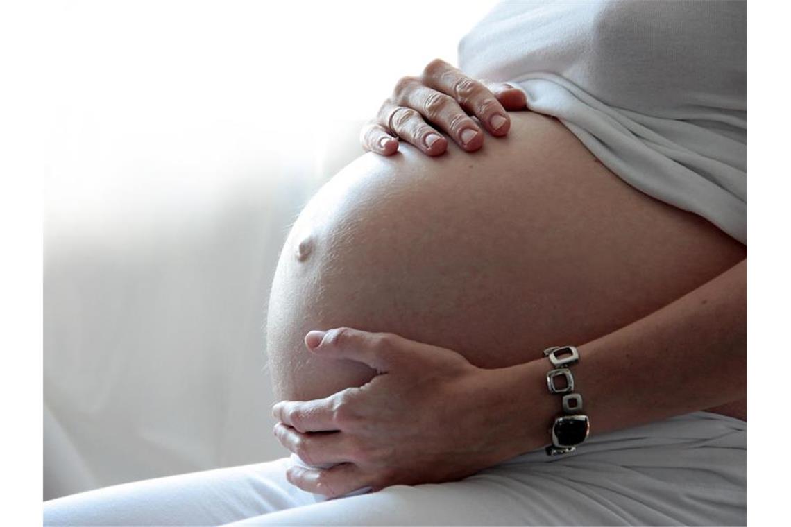Eine Frau hält ihren schwangeren Bauch. Foto: Mascha Brichta/dpa-tmn/dpa/Illustration