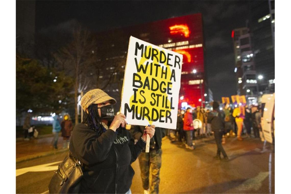 George Floyd-Prozess: Angeklagter Ex-Polizist schweigt Eine Frau hält während eines Protests in Minneapolis ein Schild mit der Aufschrift „Murder with a badge is still murder“ („Mord mit einer Dienstmarke ist immer noch Mord“). Foto: Henry Pan/ZUMA Wire/dpa